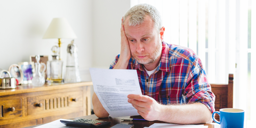 man-stressed-looking-at-electric-bill